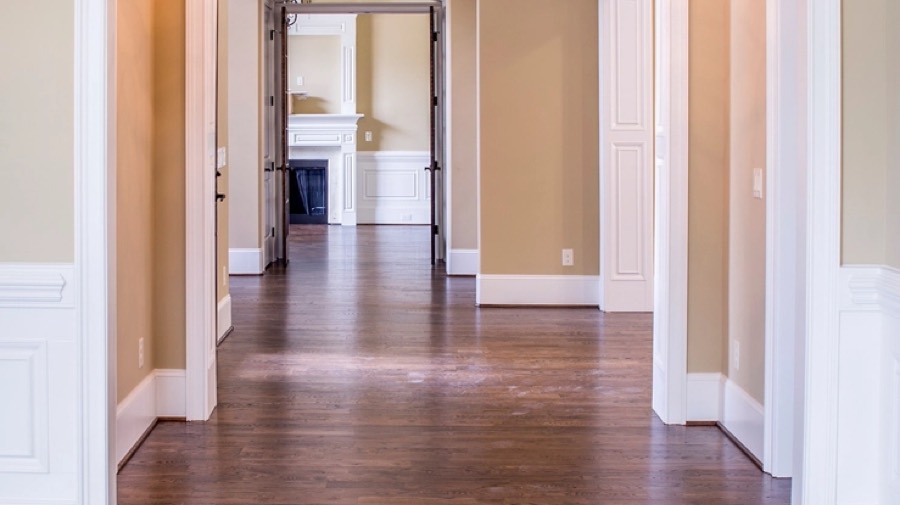A hallway before redesign, with orange-beige walls and dark varnished boards